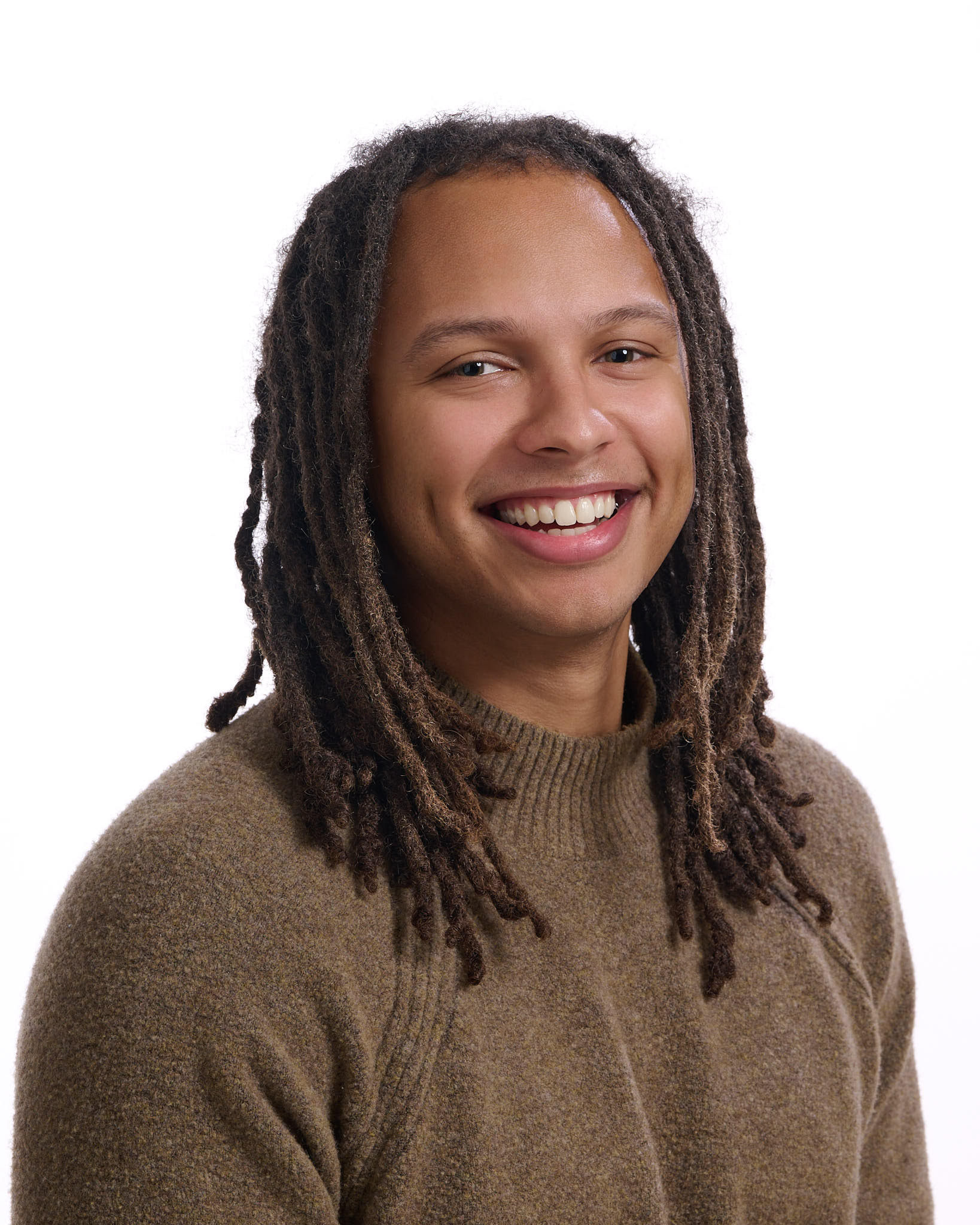 Portrait of Isaiah smiling in a warm neutral sweater